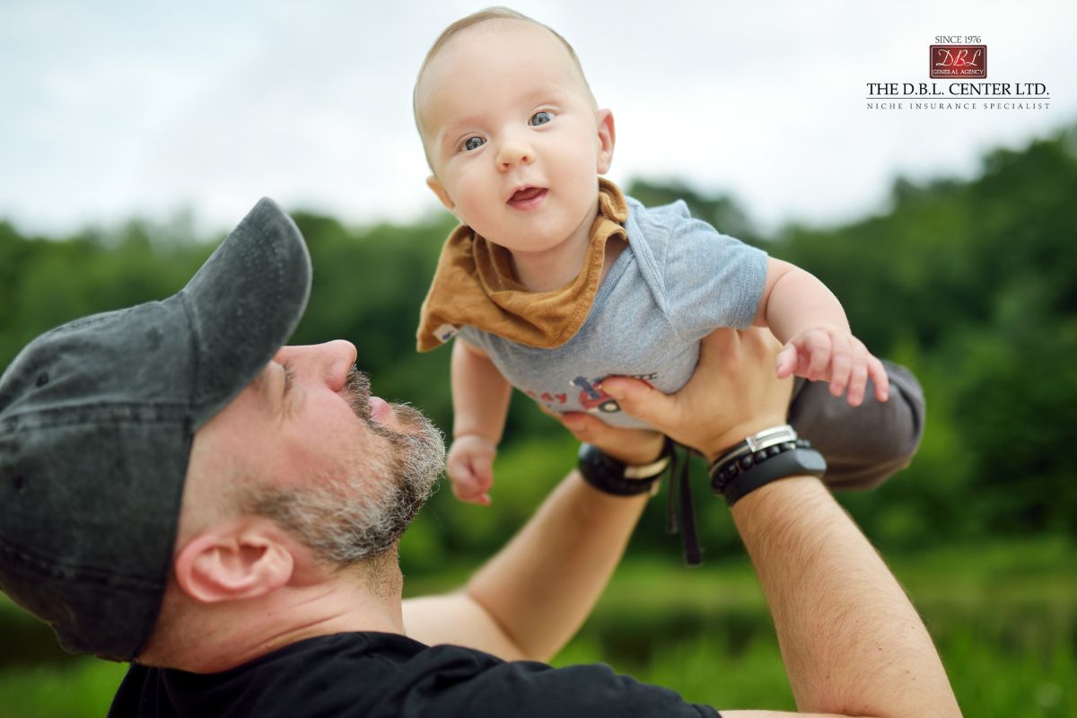 GenX dad or granddad holding up a baby son in the air.